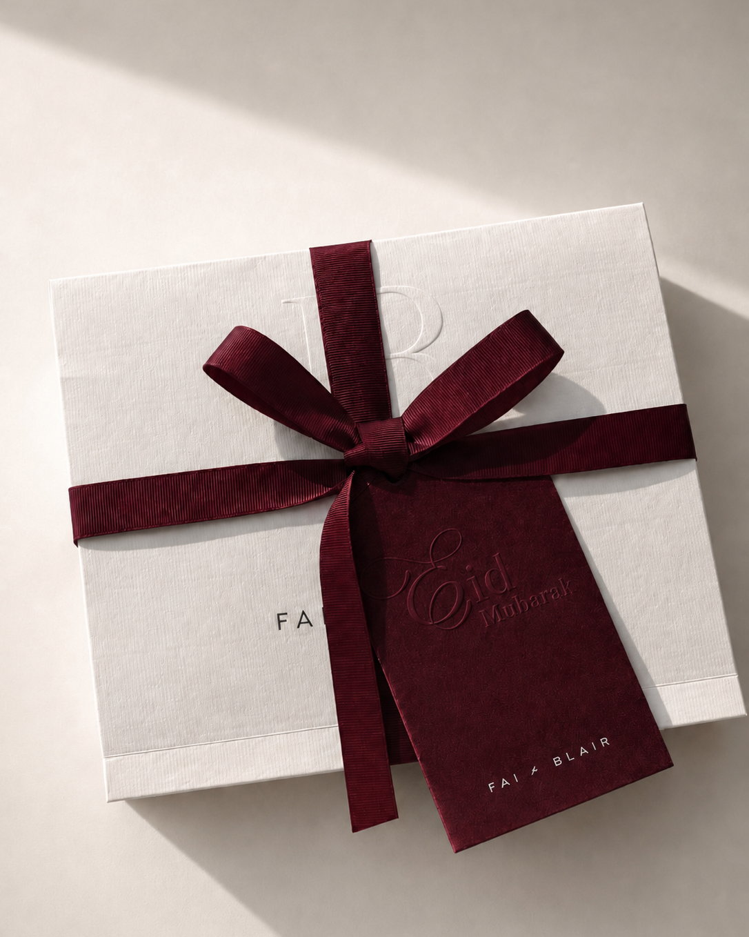 White gift box with a red ribbon and tag on a light background